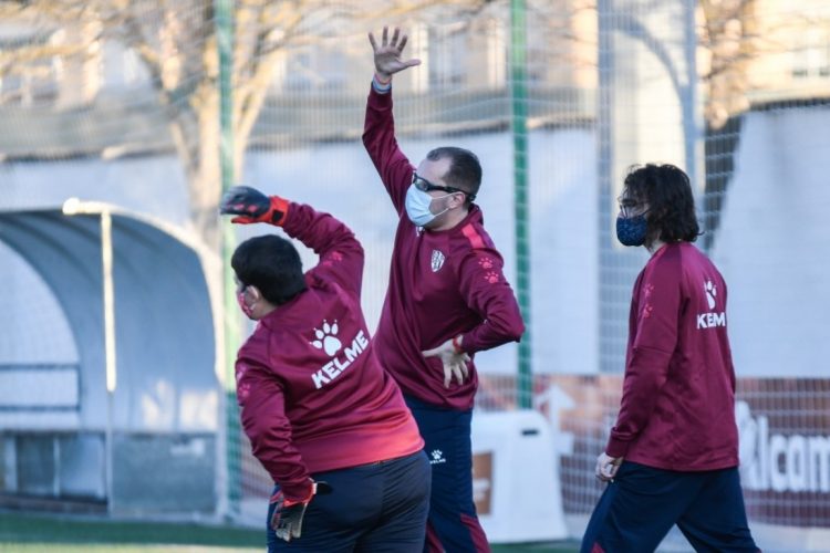 Los jugadores de la SD Huesca Genuine realizan su rutina de calentamiento en las instalaciones San Jorge