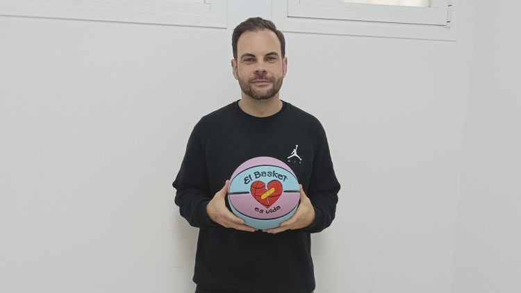 Alberto Béjar posa junto a un balón personalizado de "El Basket es Vida" en la oficina de la asociación.